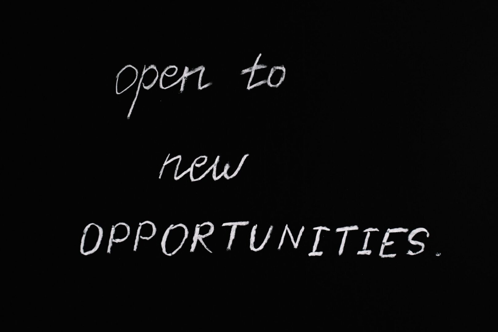 black background white chalk text open to new opportunities 2